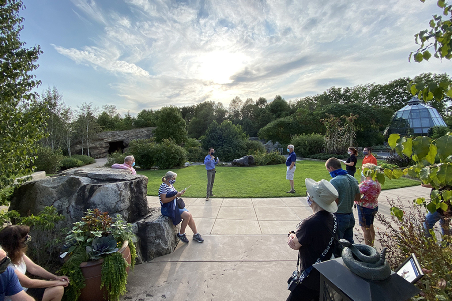 group of adults gather for tour of garden