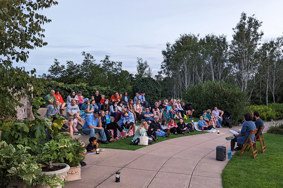 families gather in outdoor amphitheater for presentation